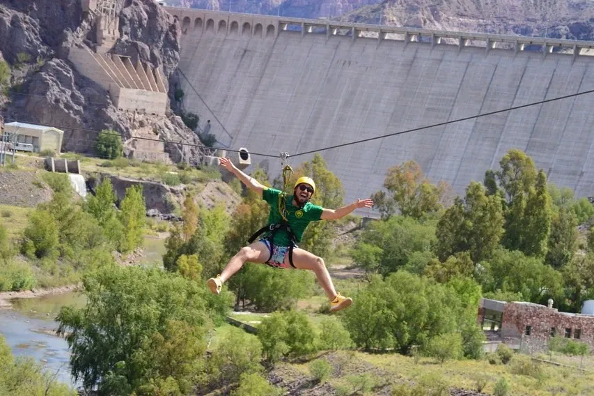 Aventura en Valle Grande: turista cruzando el río Atuel en tirolesa.
